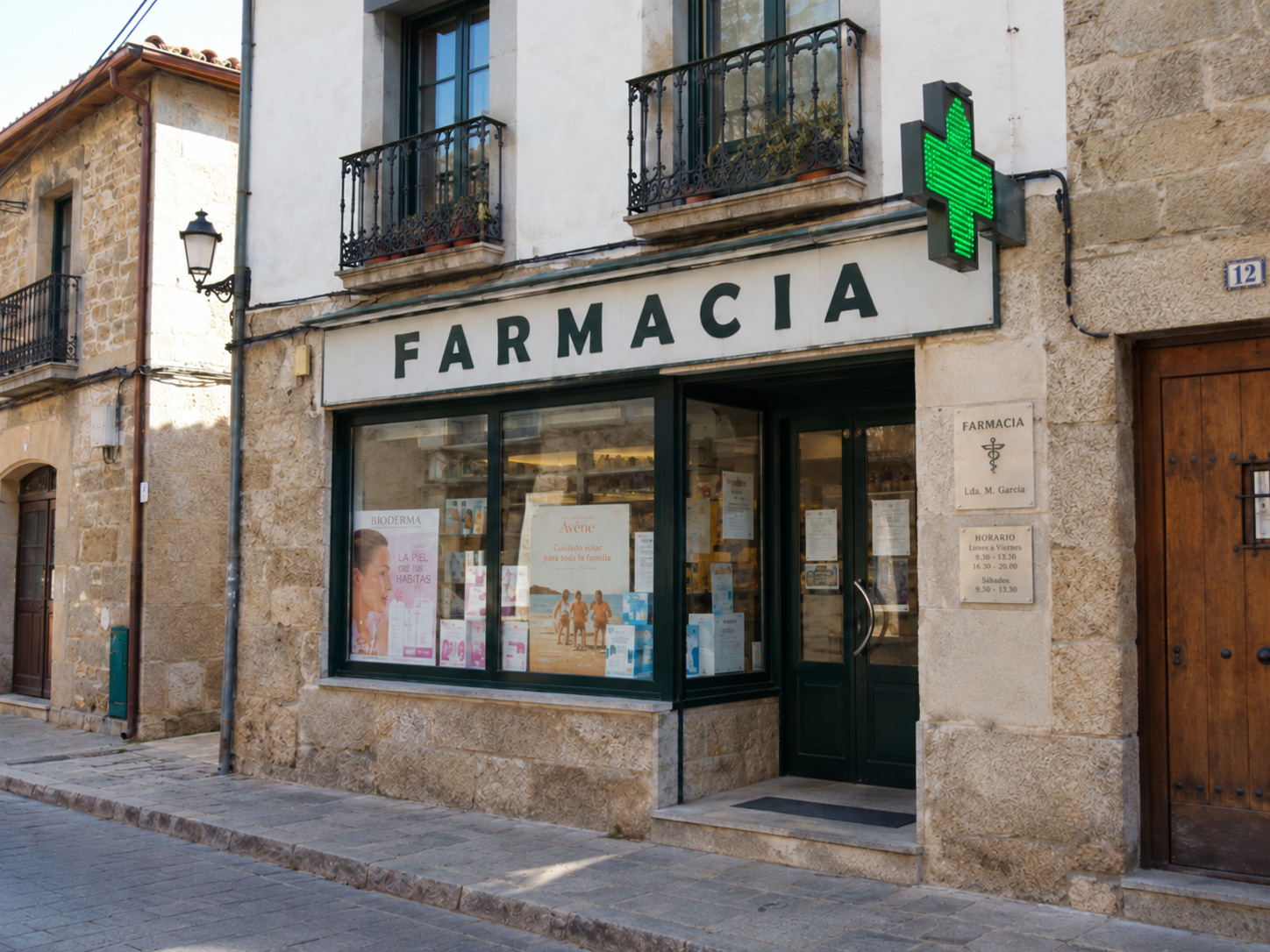 Fachada antes de la reforma, con revestimiento de piedra y rótulo blanco con letras verdes.